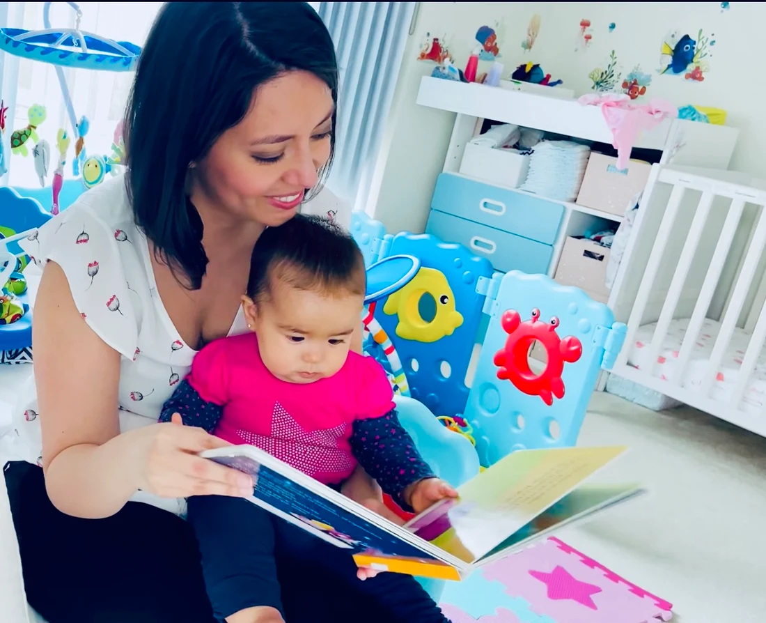 Andrea leyendo un cuento con su bebé